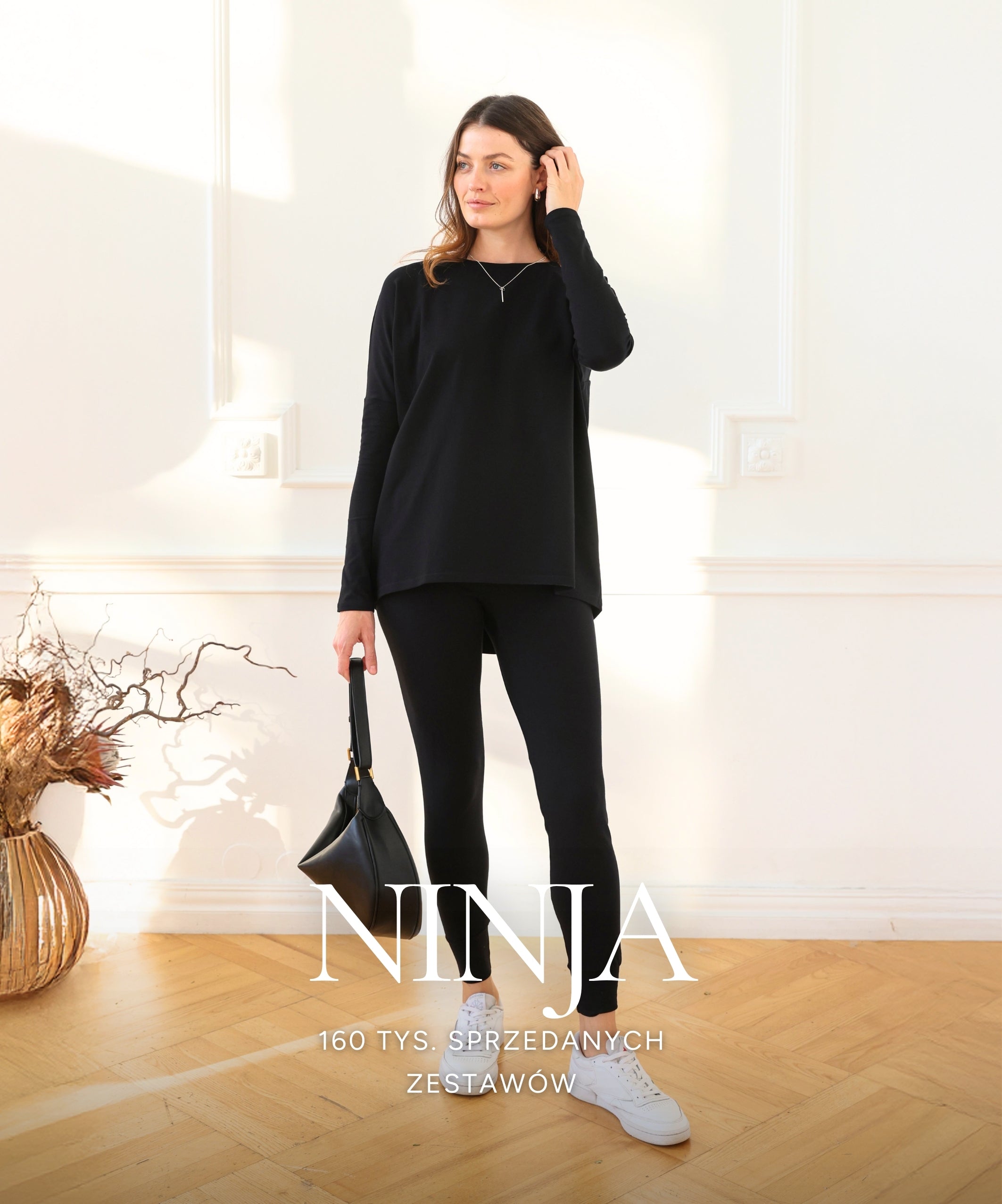 Kobieta w czarnym komplecie dresowym Ninja. Strona Zestaw Ninja